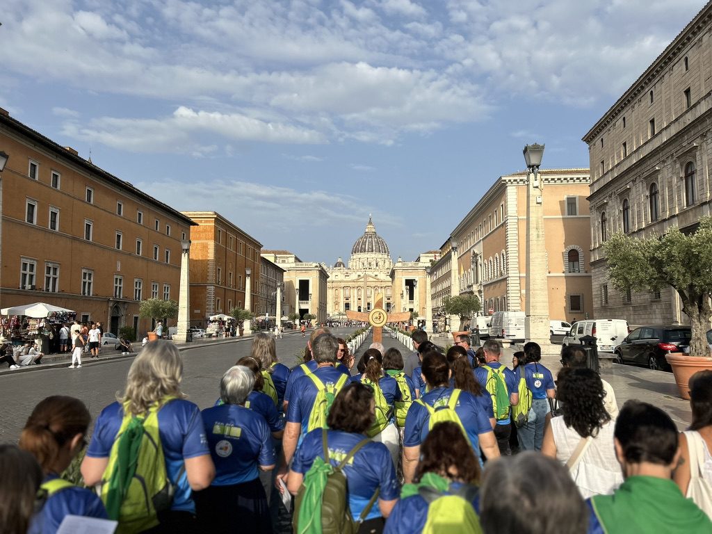 O grupo SanPioTur caminhando atrás da cruz rumo à Basílica de São Pedro, em Roma